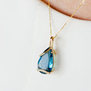 14K Yellow Gold 9.85ct Pear Shape London Blue Topaz Necklace with Swirling Diamond Accents. Bichsel Jewelry in Sedalia, MO. Shop online or in-store today!