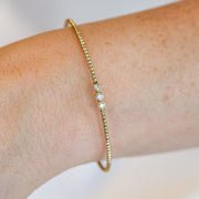 14K Yellow Gold 0.16ct Round Bezel Diamond Trio Flexible Beaded Bangle Bracelet. Bichsel Jewelry in Sedalia, MO. Shop gold and diamond jewelry online or in-store!