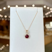 14K Yellow Gold 1.10ct Round Rhodolite Garnet Necklace with Diamond Swirl Halo. Bichsel Jewelry in Sedalia, MO. Shop gemstone styles online or in-store!